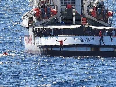 Immigrants jump off the Spanish rescue ship Open Arms, close to the Italian shore in Lampedusa, Italy, Aug. 20.