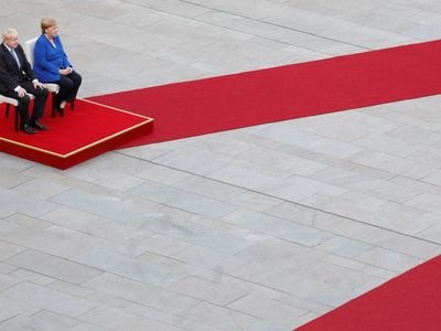 Britain's Prime Minister Boris Johnson and German Chancellor Angela Merkel sit for a photograph at the Chancellery in Berlin, Germany. It was Mr Johnson's first overseas visit since entering No 10.
