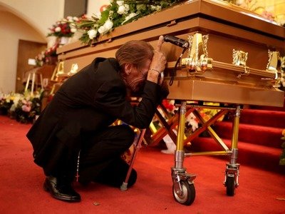 Antonio Basco cries next to the coffin containing the body of his wife, Margie Reckard, who was killed in a shooting at a Walmart store in El Paso, Texas, on Aug. 17.