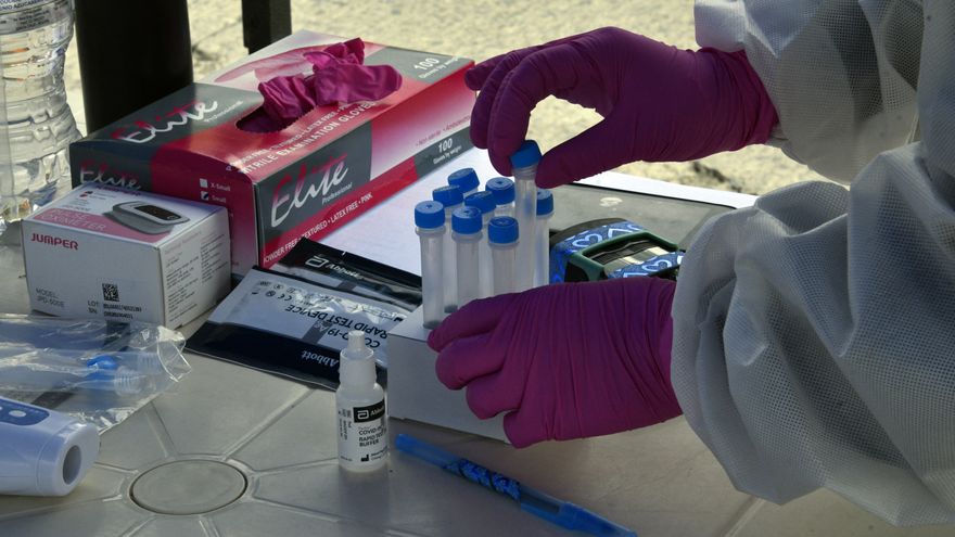 Trabajadores de salud se preparan para recolectar muestras de hisopos de personas para realizar una prueba de covid-19