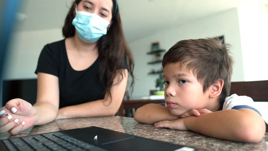 Ana María ayuda a su hijo Rafael, de cinco años, con sus clases virtuales
